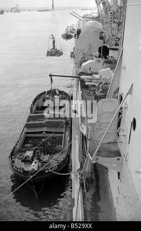 Die Crew der County-Klasse Kreuzer HMS London Einnahme an Bord Vorräte und Munition aus einem Lastkahn nachdem sie beschädigt worden war Stockfoto