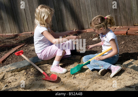 Zwei Schwestern, Mädchen, spielen im Hinterhof Sand-box Stockfoto