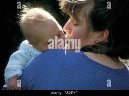 junge Mutter ihr Neugeborenes Downs Syndrom Baby kuscheln Stockfoto