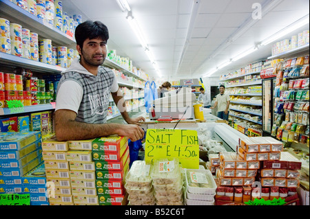 Indische Ladenbesitzer in Kamera Dalston Hackney East London UK Stockfoto