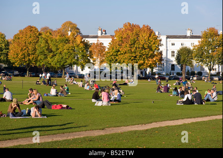 Menschen entspannen Sie sich auf warme Herbstnachmittag auf The Green Richmond TW10 Surrey London Vereinigtes Königreich Stockfoto