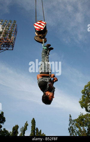 Jadugar Akash angekettet voll hängen in der Luft mit Hilfe eines Krans im Vorspiel zur Feuerleiter Show in Trivandrum, Kerala, Stockfoto