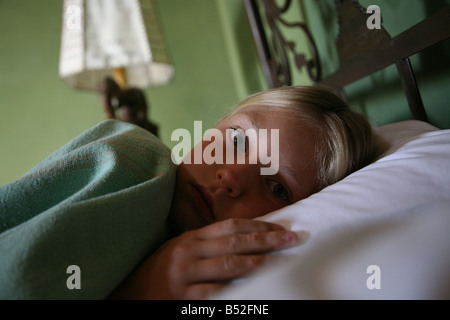 Achtjähriges Mädchen hinlegen während der Genesung von Magenverstimmung während der Reise im Ausland Stockfoto