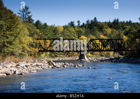 Eine alte Eisenbahnbrücke mit einer Kulisse aus fallen Laub Kreuze der Pemigewasset River in Plymouth, New Hampshire Stockfoto