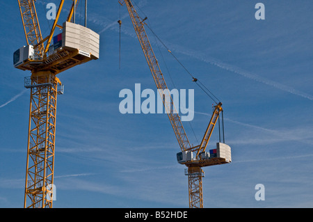 Zwei Stahl-Tiefbau Kräne hoch oben über eine Baustelle Stockfoto