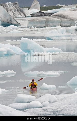 Mann unter große Eisberge in der Nähe von Bear Glacier in Resurrection Bay in der Nähe von Seward, Alaska Kajak Stockfoto