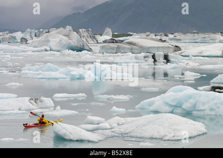 Mann unter große Eisberge in der Nähe von Bear Glacier in Resurrection Bay in der Nähe von Seward, Alaska Kajak Stockfoto