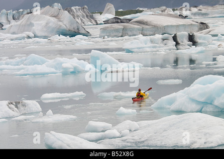 Mann unter große Eisberge in der Nähe von Bear Glacier in Resurrection Bay in der Nähe von Seward, Alaska Kajak Stockfoto