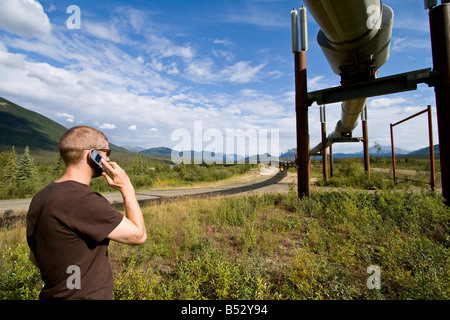 Menschen reden über Handy in der Nähe der Trans-Alaska-Pipeline. Sommer im Inneren Alaskas. Stockfoto