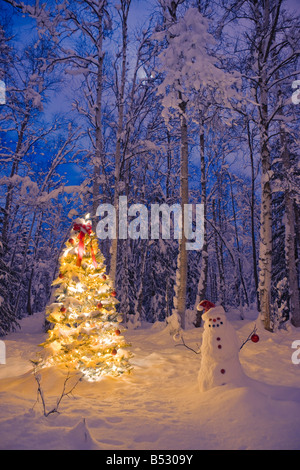 Schneemann mit Weihnachtsmütze hängende Ornamente auf einem Weihnachtsbaum im Schnee bedeckt Birkenwald in Yunan Alaska Stockfoto