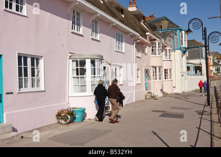 Ein paar Besucher zu Fuß, vorbei an historischen Häusern des 19. Jahrhunderts und früheren Lyme Regis Dorset Stockfoto