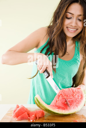 Orientalische Frau schneiden Wassermelone Stockfoto