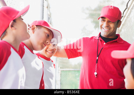 Multi-ethnischen jungen in Baseball Uniformen mit Trainer Stockfoto