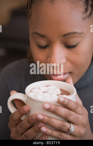 Afrikanerin, die duftenden Tasse heißen Kakao mit marshmallows Stockfoto