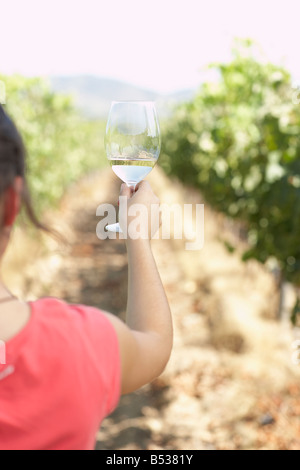 Hispanic Frau mit Glas Weißwein im Weinberg Stockfoto