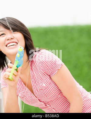 Asiatische Frau spritzende Wasser Spielzeugpistole Stockfoto