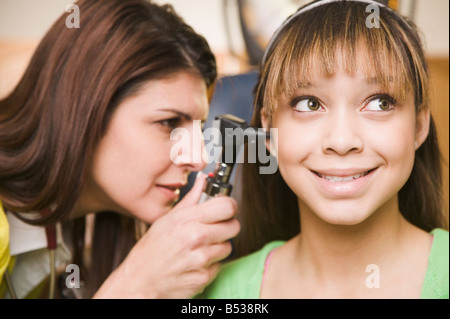 Gemischte Rassen Arzt untersuchen Teenager-Mädchen-Ohren Stockfoto