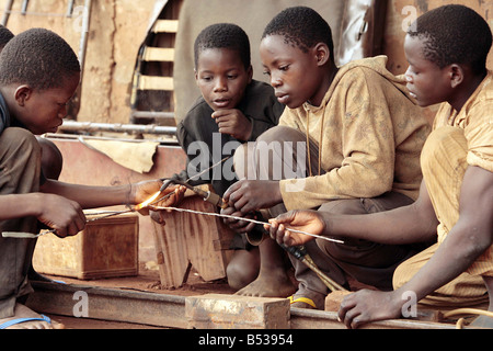 Kindersklaven in Benin Westafrika Februar 2007 Arbeitsmarkt arbeiten in Benin Westafrika kleine Kinder arbeiten in der Schmiede in Dan Tokpa Cotouno versteckt in einer Ecke dieses foul und weitläufige Markt jungen im Alter von fünf Mühe in der eiternden Hitze Weg, bevor Sie die Gesichter dieser elende Kinder Sie den Klang ihrer Versklavung sehen hören, das Geschrei des schweren Blei auf Platten aus Metall Barefoot Hämmer, und zerlumpten Kinder diese Jugendlichen wurden verkauft für nur 10 von ihren Eltern zu Kind Menschenhändler verkaufen, die sie auf, um ohne Bezahlung und ohne Hoffnung in Sweatshops Mamoutche erniedrigend eine Angst zu arbeiten Stockfoto