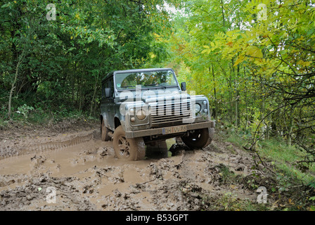 Schlammigen 2008 Land Rover Defender 110 TD4 Fahrt entlang einen Waldweg in das Weserbergland. Stockfoto