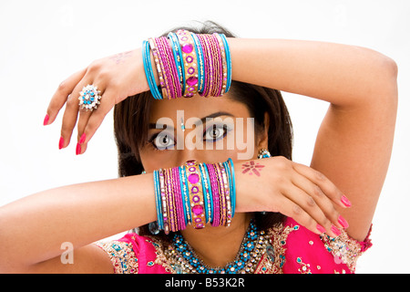 Schöne Gesicht einer bengalischen Braut mit ihren Armen über dem Kopf bedeckt mit bunten Armbänder isoliert Stockfoto