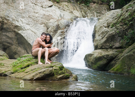 Paar, Schwimmen im Pool in der Nähe von Wasserfall Stockfoto