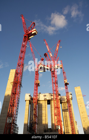 4 Turmdrehkrane gegen einen blauen Himmel mit den Aufzugsschächten und Treppenhäusern, die aus einer großen Gebäudeentwicklung im Zentrum von London entstehen Stockfoto