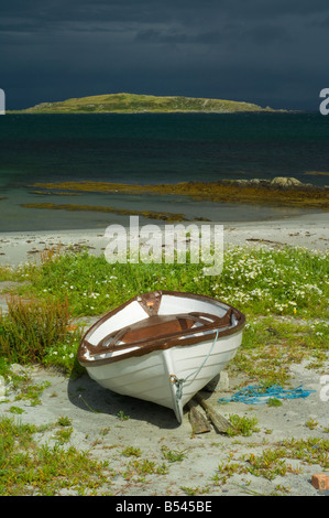 Boot am Strand unter Blumen Meer Mayweed in Merchiston suchen über kleine Inseln Bucht auf Eilean Bhride, Isle of Jura. Stockfoto