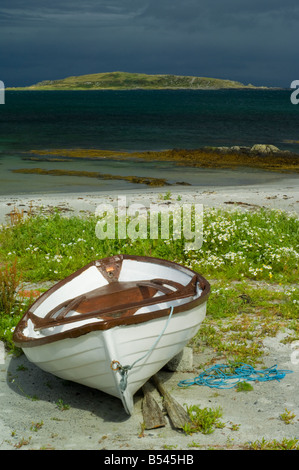 Boot am Strand unter Blumen Meer Mayweed in Merchiston suchen über kleine Inseln Bucht auf Eilean Bhride, Isle of Jura Stockfoto