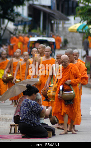 Mönche machen ihre täglichen Runden um Almosen von buddhistischen Anhänger In Luang Prabang zu erhalten Stockfoto