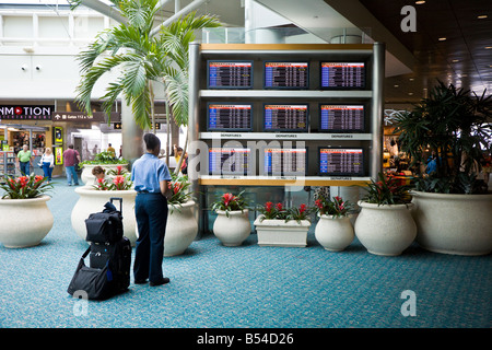 Weiblichen Flugbegleiter, Blick auf die an- und Abreise Zeitplan am Orlando International Airport Stockfoto