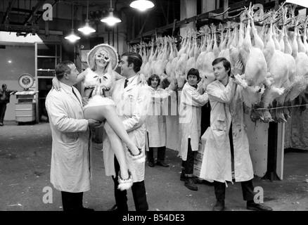 Moden des 11. jährlichen Geflügel Feder Hut Wettbewerbs wurden im Café Royal, Regent Street gezeigt. Irene Moffatt nahm eine Reise hinunter Smithfield Market, die Träger zu zeigen, wie ein guter Vogel aussehen soll! Sie trägt den prämierten Eintrag in das Kleidungsstück Abschnitt "Flauschige Küken" bezeichnet einen Badeanzug, Hut, Hausschuhe und Schutzbrillen, die ganz aus Truthahnfedern. Das Outfit machte Frau N. Murphy von Cork, Irland, der gewinnt £35, und nahm ihr 40 Stunden zu machen. Irene ist abgebildet, "Gewicht" auf die Türkei-Waage. November 1969 Z11371 Stockfoto