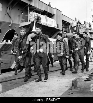 Unterhaltung. Militär Marine: Zwanzig Schiffe Taucher von HMS Hermes mit 14 jährige Janet Abercombie trat der englischen und walisischen Tauchen Champion, machen eine verbotene 45 ft Tauchen in Portsmouth Harbour aus dem oberen Deck der HMS Hermes. Es war alles zugunsten der Förderung Aufnahmen für eine Sonderausgabe von Thames Television "Opportunity Knocks" am 10. November untersucht werden. Janet Abercombie mit einigen der Taucher von HMS Hermes, vor dem Tauchgang. November 1969 Z10604 Stockfoto