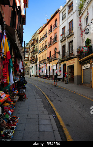 Eine Straße gesäumt von touristischen Läden, die hellen Spanisch und nordafrikanischen waren in Granada, Andalusien, Spanien. Stockfoto