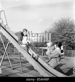 Familienfotos von Alan und Maureen Rothwell, mit Babys, Tody im Alter von 2 Jahren, und Ben im Alter von 16 Monaten, spielen auf der Schaukel und Rutschen bei ihrer örtlichen Spielplatz. ; November 1969; Z11219-001 Stockfoto