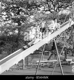 Familienfotos von Alan und Maureen Rothwell, mit Babys, Tody im Alter von 2 Jahren, und Ben im Alter von 16 Monaten, spielen auf der Schaukel und Rutschen bei ihrer örtlichen Spielplatz. ; November 1969; Z11219-002 Stockfoto