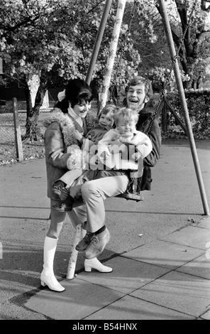 Familienfotos von Alan und Maureen Rothwell, mit Babys, Tody im Alter von 2 Jahren, und Ben im Alter von 16 Monaten, spielen auf der Schaukel und Rutschen bei ihrer örtlichen Spielplatz. ; November 1969; Z11219-012 Stockfoto