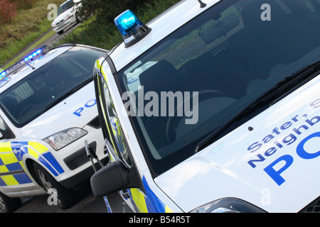 Zwei Polizeiautos Parken als eine Straßensperre mit blinkendem Blaulicht über eine Kreuzung in Somerset, England Stockfoto