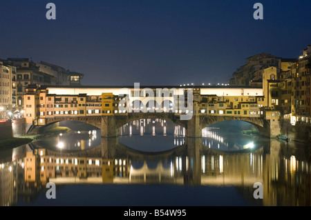 Eine West-Seitenansicht der Brücke Ponte Vecchio und traditionelle Gebäude spiegelt sich in den Fluss Arno in der Nacht. Stockfoto