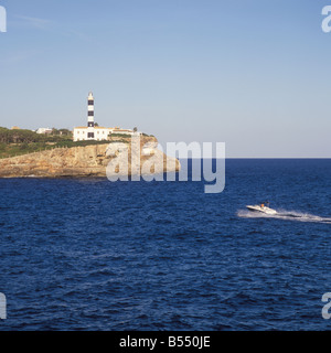 Motorboot Appraching Eingang mit Leuchtturm an der geschützten Bucht Ankerplatz von Porto Colom Ostküste Mallorca Mallorca Stockfoto