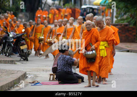 Mönche machen ihre täglichen Runden um Almosen von buddhistischen Anhänger In Luang Prabang zu erhalten Stockfoto