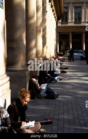 Französische Kunst-Studenten sitzen auf dem Boden außerhalb der Comédie Française in Place Colette Paris Frankreich Stockfoto