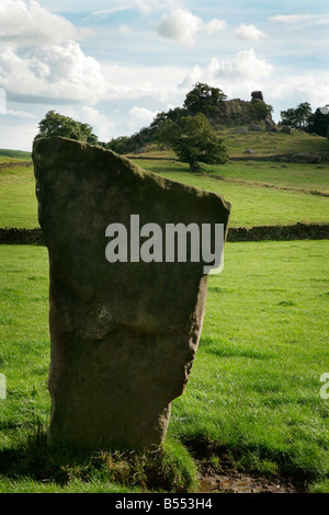 Ein stehender Stein Harthill Moor Steinkreis in Derbyshire mit Robin Hoods Stride im Hintergrund Stockfoto