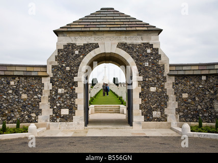 Zwei Menschen, die zu Fuß zwischen den Gräbern am Eingang zum Tyne Cot British War Memorial Friedhof Belgien Stockfoto