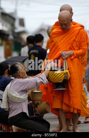 Mönche machen ihre täglichen Runden um Almosen von buddhistischen Anhänger In Luang Prabang zu erhalten Stockfoto