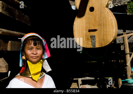 Porträt einer Padong Langhals Frau steht in der Nähe ein traditionelles Saiteninstrument Stockfoto