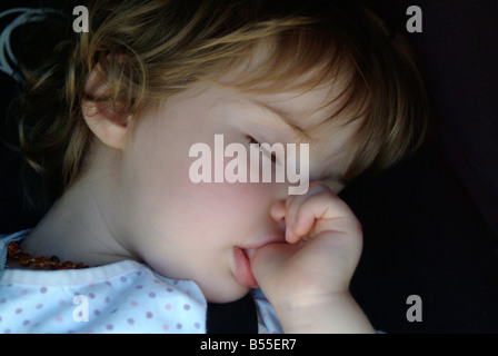 2 Jahre altes Mädchen schlief ihr Daumenlutschen Stockfoto