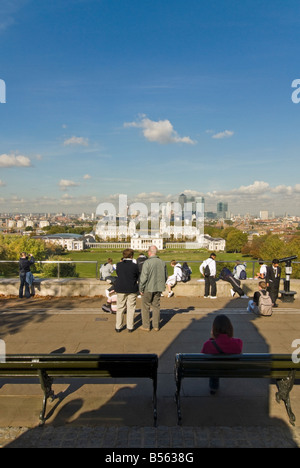 Vertikale Weitwinkel von Touristen im Greenwich Park Hill genießen Sie die spektakuläre Aussicht über Greenwich Park in Richtung Canary Wharf. Stockfoto