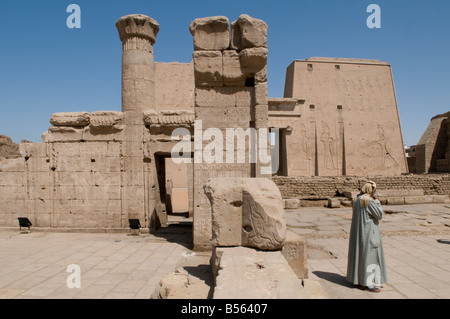 Ägyptischen Mann inmitten der Ruinen der antiken Tempel von Edfu, dem Falkengott Horus geweiht, in ptolemäischer Zeit zwischen 237 und 57 v. Chr. gebaut. Ägypten Stockfoto