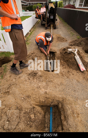 Man zieht durch Wasserleitungen nach dem Bohren unter Boden Löcher für Wasserleitungen Stockfoto