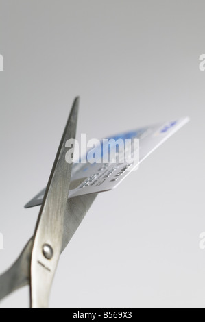 Kreditkarte schneiden mit Schere Stockfoto